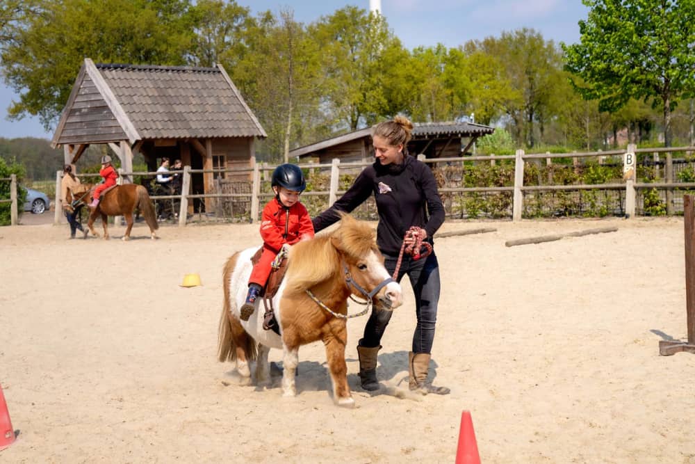 FarmCamps BoeBaDoe Limburg jongen pony juf rijden in bak 