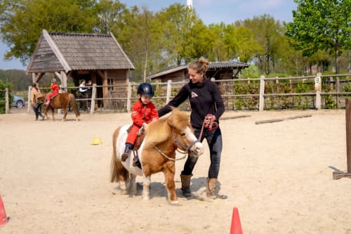 FarmCamps BoeBaDoe Limburg jongen pony juf rijden in bak 