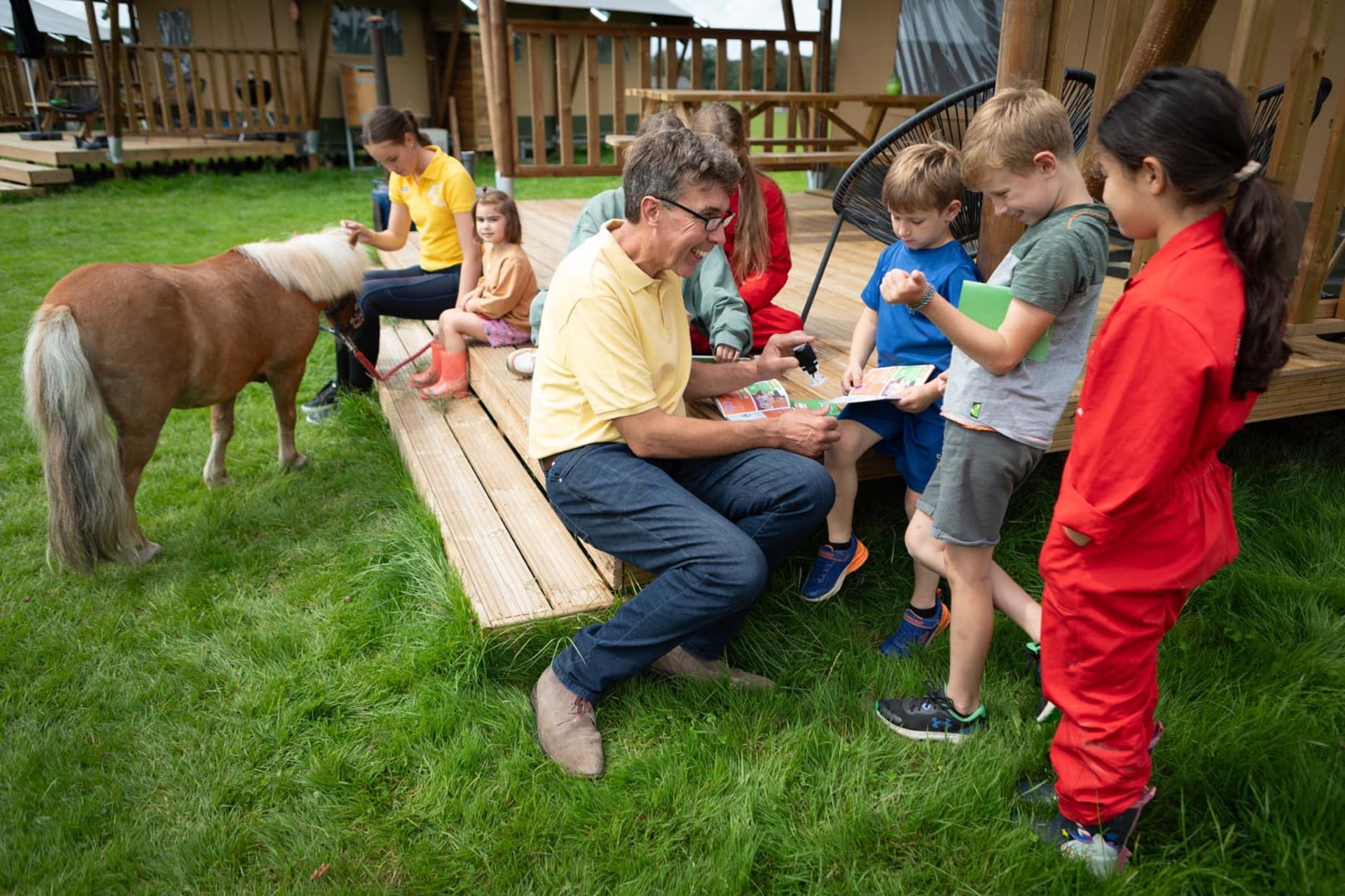 FarmCamps Holzik Stables Overijssel paspoorten stempelen bij tent boer lachen pony bij tent