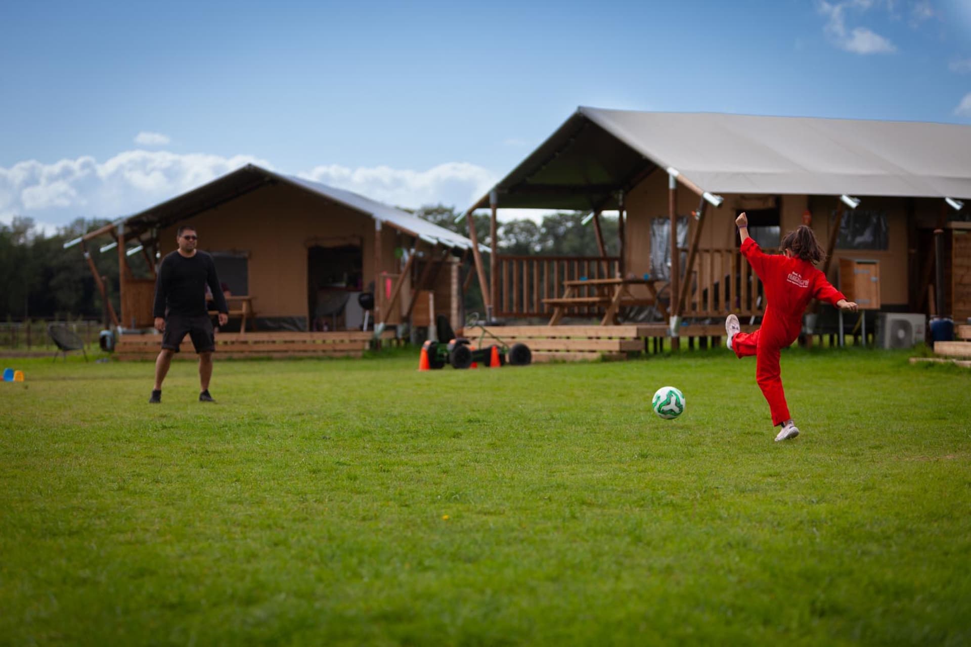FarmCamps Holzik Stables Overijssel meisje en vader voetballen op veld overalletje