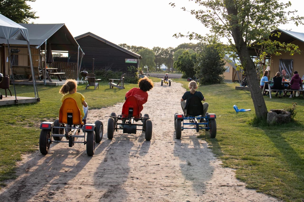 Kinder fahren mit Gokarts über den Bauernhof bei FarmCamps