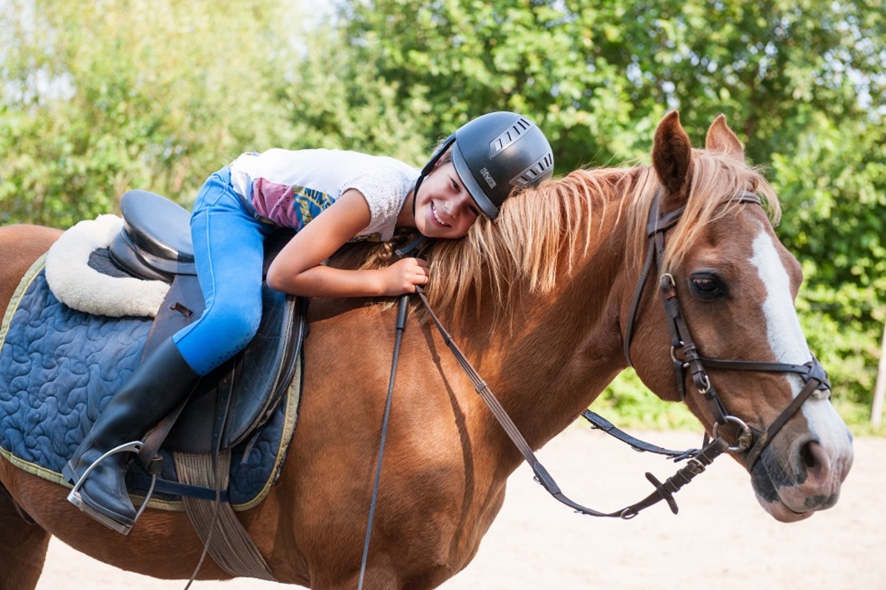 meisje knuffelt paard