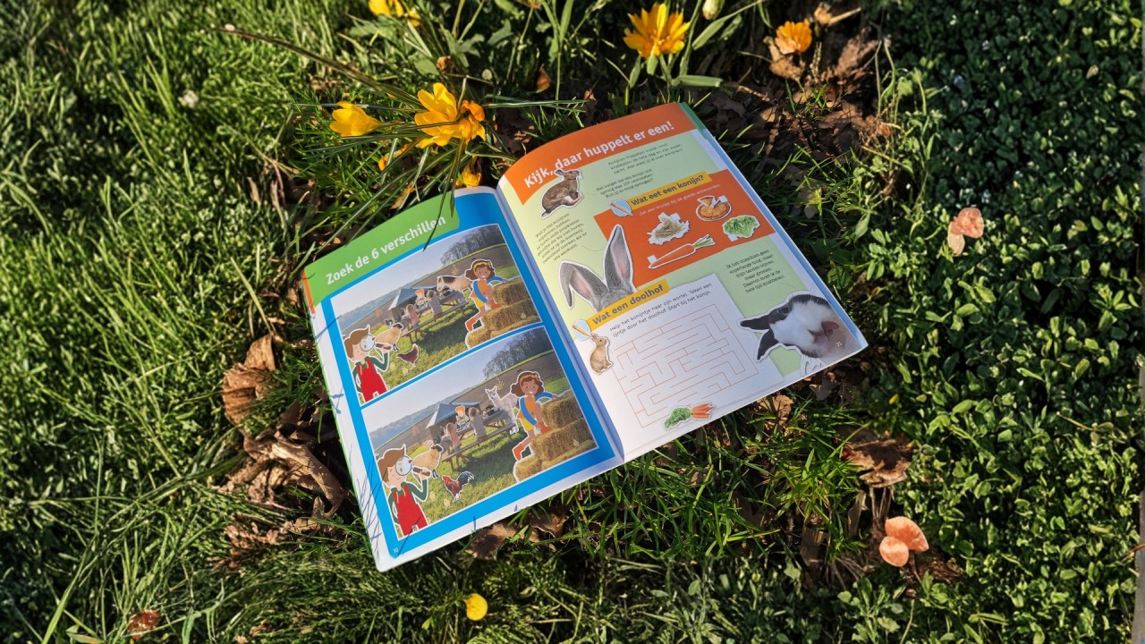 FarmCamps Kinder-Entdeckerbuch liegt auf einem Tisch mit Buntstiften, Frühstück und Bauernhof-Atmosphäre