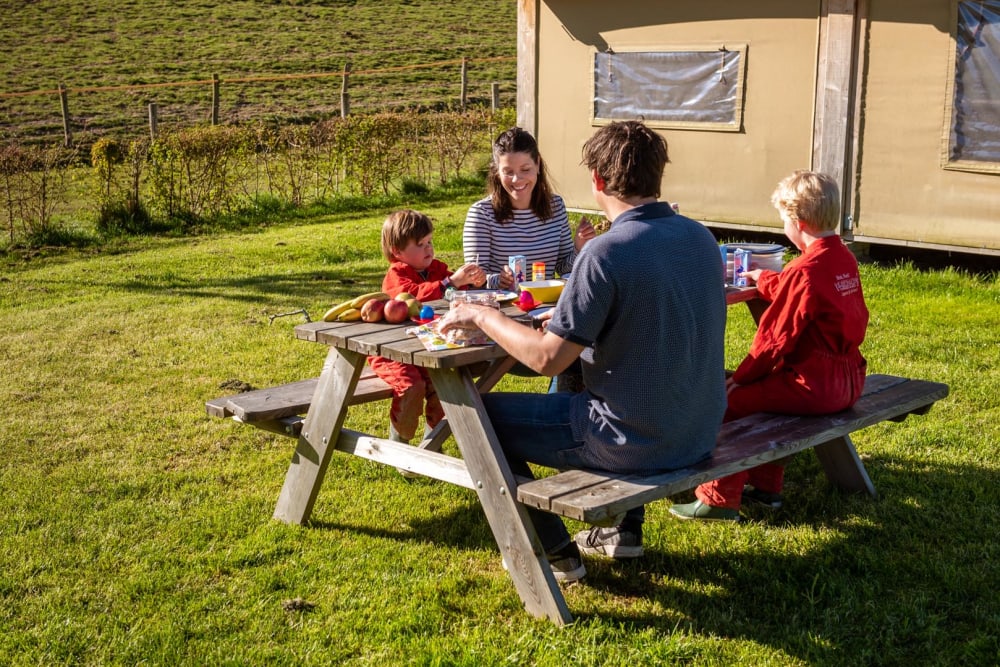 Gezin eet een lekker ontbijt bij FarmCamps tijdens Hemelvaart