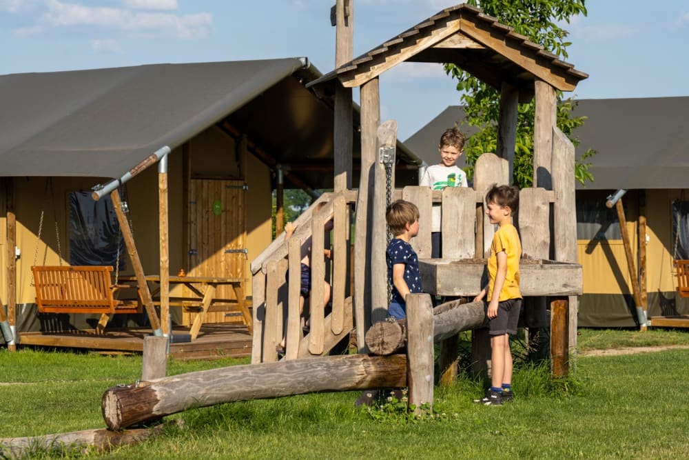 Kinderen spelen op een speeltoestel tijdens hun vakantie met kinderen bij FarmCamps