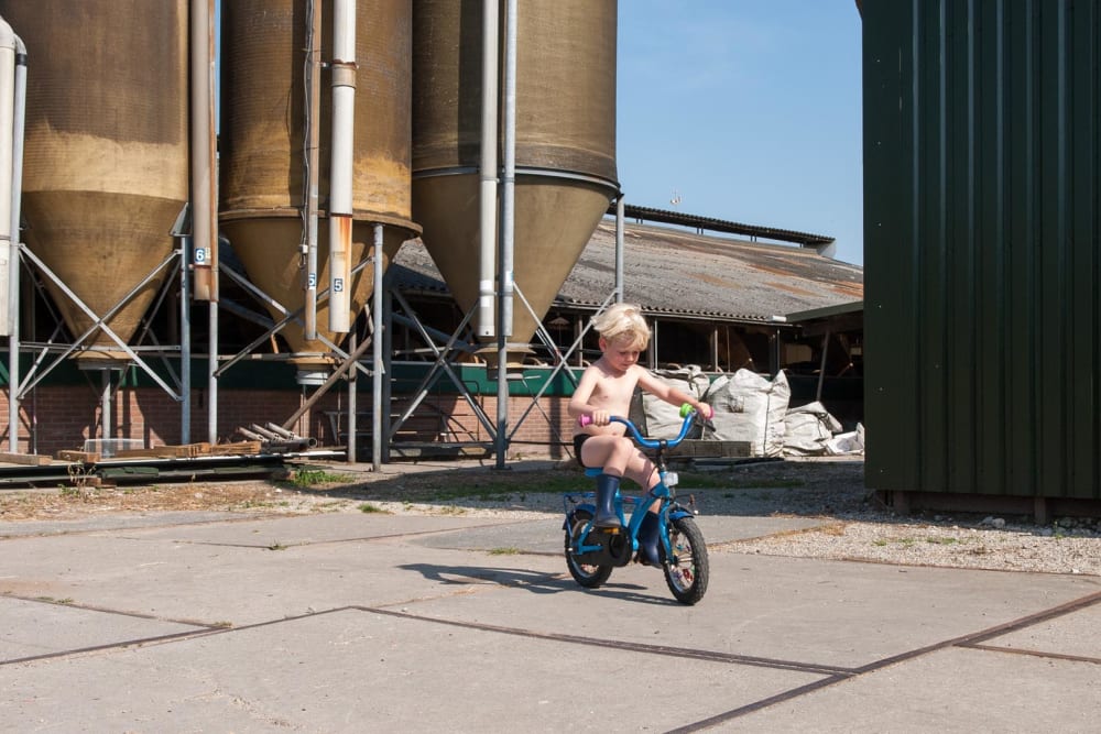 Child riding a bike on the farm during a farm holiday
