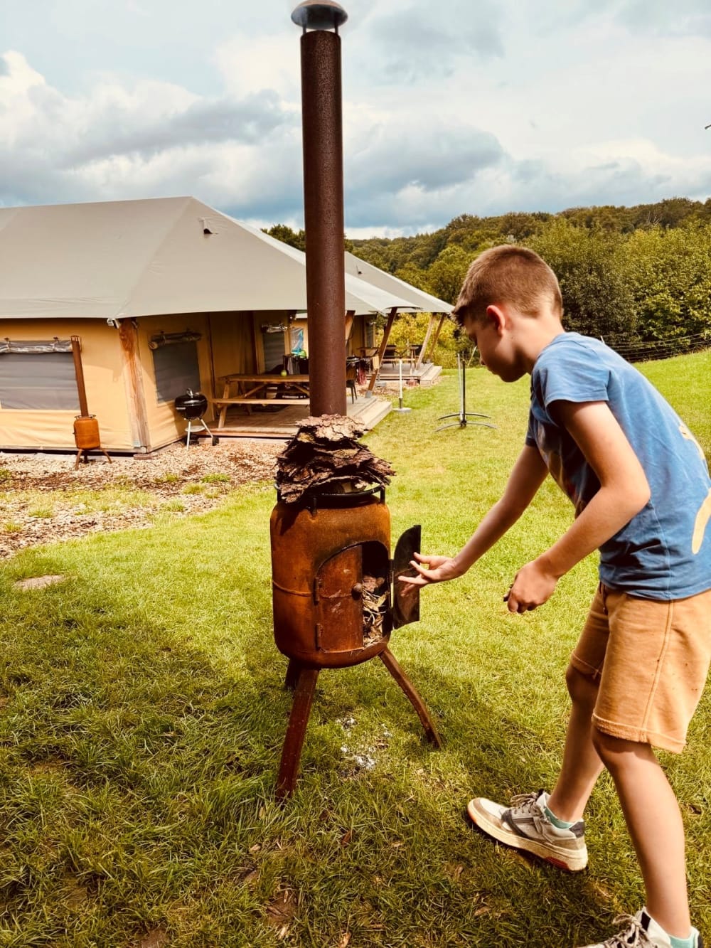 Jongetje steekt houtkachel aan op FarmCamps boerderij in Duitsland