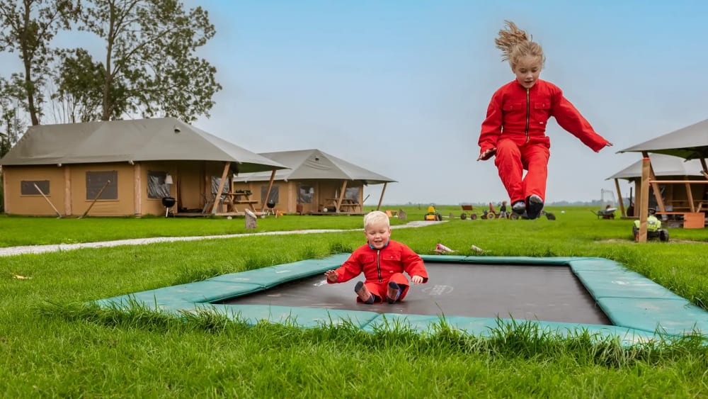 FarmCamps_De_Oostermaat_Overijssel_kinderen_trampoline_uitzicht_blij_tentenveld