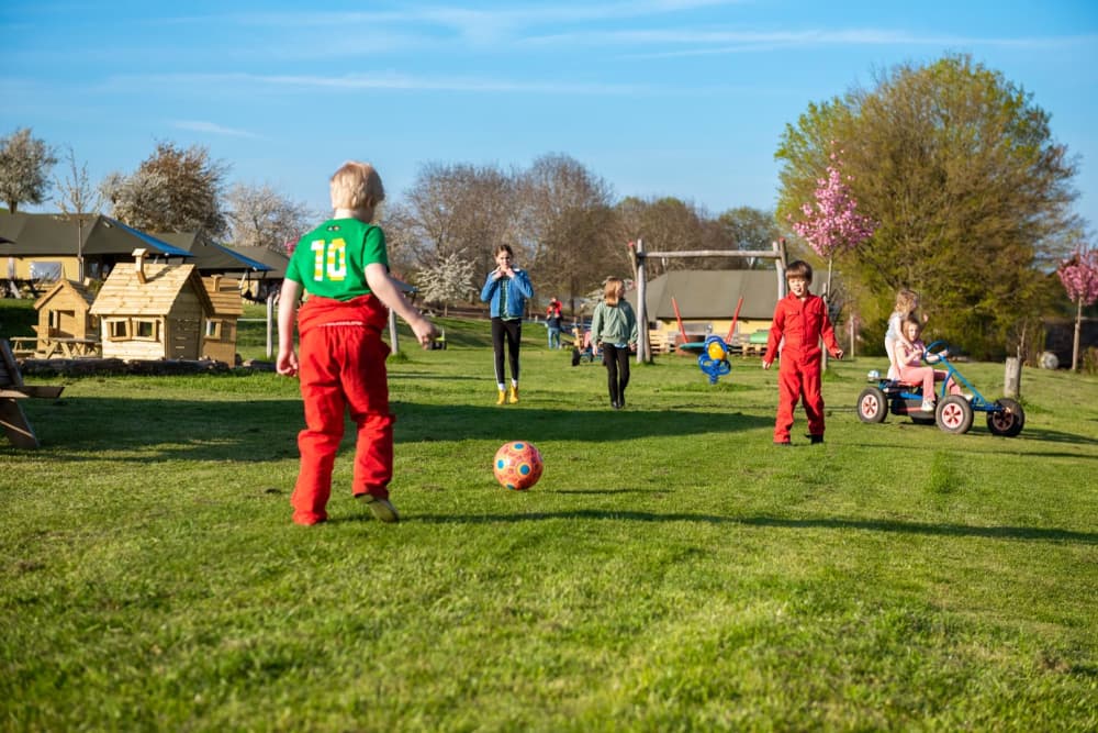 Kinderen voetballen op de boerderij bij FarmCamps tijdens de Amstel Gold Race