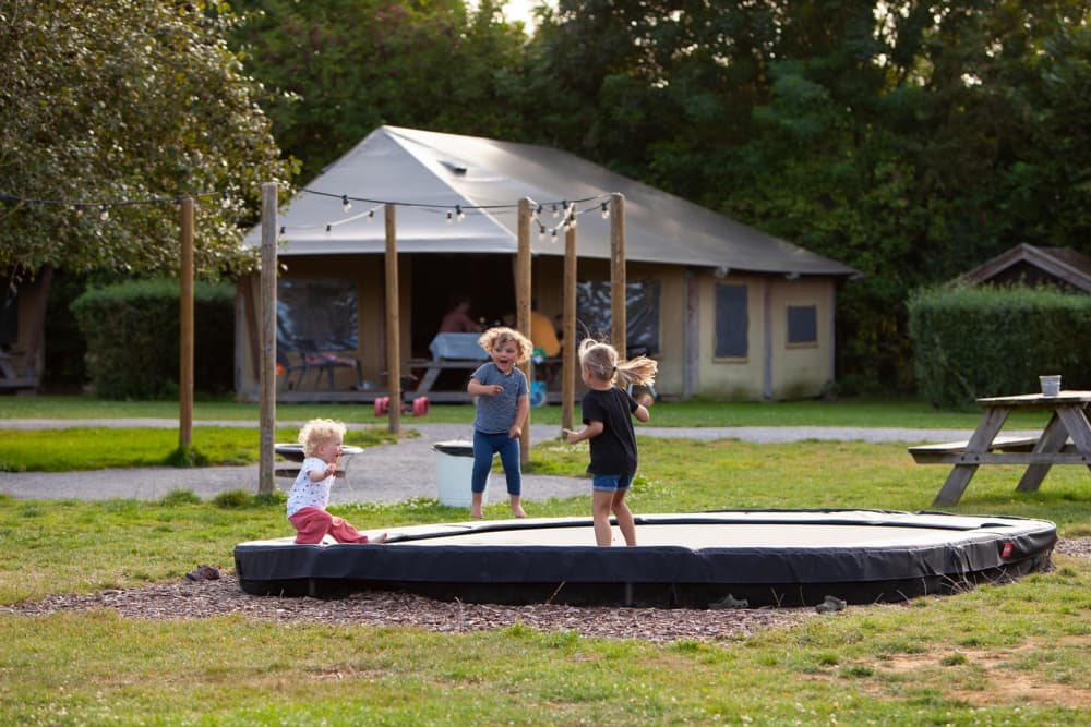 kinderen spelen op de trampoline bij Safaritenten