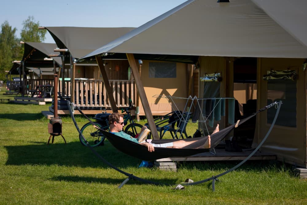 FarmCamps_De_Bosrand_man_leest_boek_in_hangmat