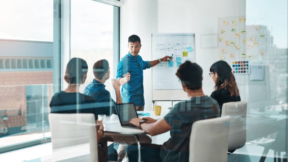 colleagues at work in a meeting with a whiteboard